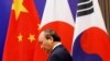 Perdana Menteri Vietnam Nguyen Xuan Phuc melewati bendera China, Jepang, dan Korea Selatan saat menghadiri KTT ASEAN ke-37 di Hanoi, Vietnam 14 November 2020. (Foto: REUTERS/Kham)
