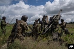 Prajurit Ukraina bersiap untuk menembaki posisi Rusia dari howitzer M777 yang dipasok AS di wilayah Kharkiv, Ukraina, 14 Juli 2022. (Foto: AP)