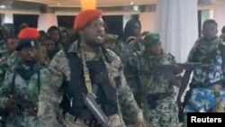 A man in military fatigues speaks as others stand behind him inside the Palace of the Nation during an attempted coup, in Kinshasa, Democratic Republic of Congo, May 19, 2024 in this screen grab from a social media video. (Christian Malanga/Handout via Reuters) 