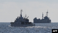 Kapal penjaga pantai Filipina berpatroli di dekat kapal angkatan laut BRP Sierra Madre, 23 April 2023, tempat marinir Filipina ditempatkan untuk menegaskan klaim Manila di Laut Cina Selatan yang disengketakan. (Foto: AFP)
