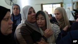 Mourners cry after taking the last look at the body of Mahmoud Abu Saan, 18, at a mosque during his funeral in the West Bank city of Tulkarem, Aug. 4, 2023. 