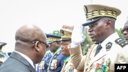 FILE - Head of Gabon's elite Republican Guard, General Brice Oligui Nguema, right, is decorated by Gabon Prime Minister Alain Claude Bilie Bie Nze in Libreville on Aug. 16, 2023, ahead of Gabon Independence Day, celebrated Aug. 17, 2023.