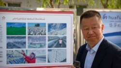 中國政府組織外國記者參觀新疆維吾爾自治區阿克蘇期間，新疆華孚色紡集團有限公司總經理李強在其公司宣傳板前講話。 （2021年4月20日）