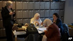 FILE - Teachers work in the teachers lounge at Ibn Khaldoun, a private Muslim school, in Marseille, southern France, April 18, 2024.