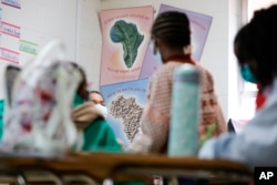 Posters of traditional food sit on a classroom wall at the Kilombo Academic and Cultural Institute, March 28, 2023, in Decatur, Ga.