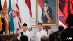 Presiden terpilih Indonesia Prabowo Subianto (kiri) dan Wakil Presiden terpilih Gibran Rakabuming Raka (kanan) di depan potret Presiden Indonesia Joko Widodo usai rapat pleno KPU di Jakarta, 24 April 2024. (Yasuyoshi CHIBA / AFP)