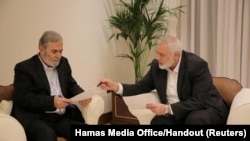 Pemimpin Hamas Ismail Haniyeh dan pemimpin Jihad Islam Ziyad Al Nakhalal berdiskusi tentang usual gencatan senjata sebelum mereka memberi jawaban kepada para mediator Qatar dan Mesir, di Doha, Qatar, Selasa, 11 Juni 2024. (Foto: Hamas Media Office via Reuters)