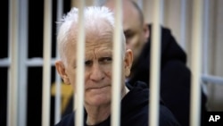 FILE - Ales Bialiatski, ketua kelompok hak asasi Belarus Vyasna, duduk di balik jeruji terdakwa selama sidang pengadilan di Minsk, Belarusia, Kamis, 5 Januari 2023.