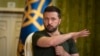 Presiden Ukraina Volodymyr Zelenskyy memberi isyarat saat konferensi pers di Kyiv, Ukraina, Senin, 15 Juli 2024. (AP Photo/Efrem Lukatsky)