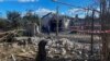 Pria lokal berdiri di samping bangunan tempat tinggal yang rusak akibat serangan rudal Rusia, di tengah serangan Rusia ke Ukraina, di desa Obukhivka, wilayah Dnipropetrovsk, Ukraina 18 Oktober 2023. (REUTERS/Mykola Synelnykov)