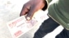 A man in Harare holds a Zimbabwe dollar, April 4, 2024, which is worth less than a cent. Most traders are refusing to accept it. (Columbus Mavhunga/VOA) 