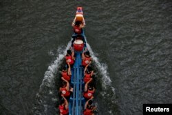 Participants compete in a dragon boat during the annual Dragon Boat Festival in Taipei, Taiwan, June 22, 2023.