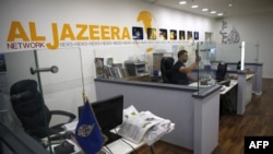 FILE - An employee of the Qatar-based news network and TV channel Al Jazeera is seen at the channel's Jerusalem office, July 31, 2017. 