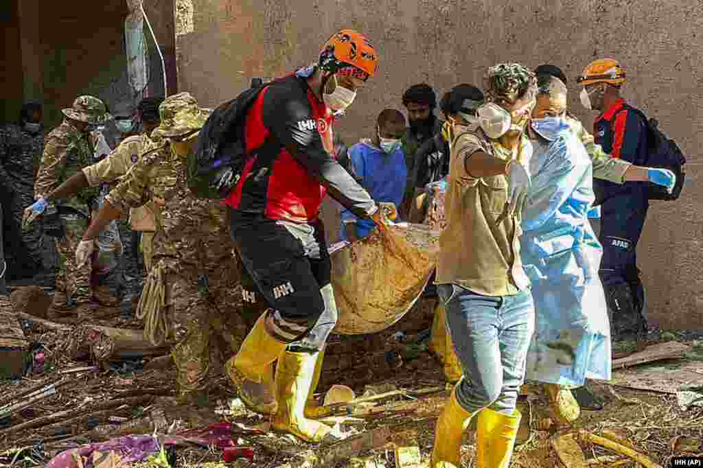 In this photo provided by Turkey's IHH humanitarian aid group, rescuers retrieve the body of a flooding victim in Derna, Sept.13, 2023.