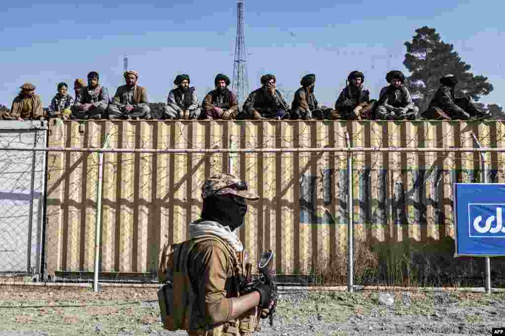 Petugas keamanan Taliban menonton laga para penunggang kuda Afghanistan dalam kompetisi olahraga tradisional Asia Tengah, buzkashi, selama pertandingan persahabatan antar provinsi di sebuah lapangan di Kabul.
