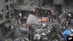 Palestinians inspect the damage of destroyed buildings following Israeli airstrikes on Gaza City, Oct. 27, 2023.