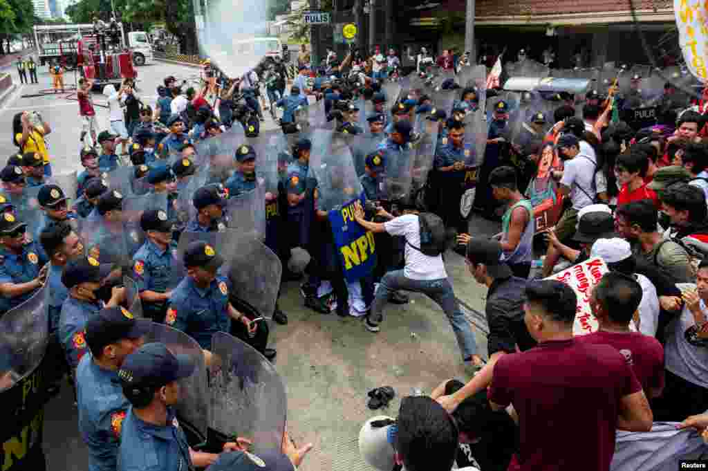 Polisi menghalangi aktivis Filipina saat berjalan menuju Kedutaan Besar AS dalam aksi protes memperingati Hari Buruh di Manila, Filipina, 1 Mei 2024. (REUTERS/Lisa Marie David)