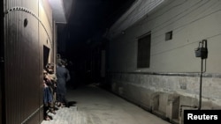 Children stand in the entrance of a house after a tremor shook Peshawar, Pakistan, March 21, 2023. 