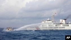 一艘中國海警船2023年12月10日在有爭議的南中國海水域對菲律賓海軍運營的補給船使用水砲。（美聯社照片）
