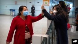 중국 베이징 서우두 국제공항 입국장 이용객들이 마스크를 쓴 채 인사하고 있다. (자료사진)