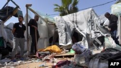 Palestinians check the damage at a makeshift camp for displaced people in front of Al-Aqsa Hospital in Deir al Balah, Gaza Strip, after it was hit by Israeli airstrikes on March 31, 2024.