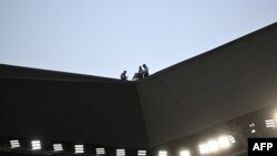 在若弗魯瓦·吉夏爾體育場舉行比賽期間，安保人員在體育場屋頂上工作。（2023年9月17日）