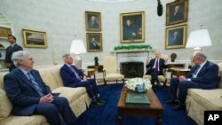 FILE - Sen. Mitch McConnell of Ky., Speaker of the House Kevin McCarthy of Calif., and Sen. Chuck Schumer of N.Y., listen to President Joe Biden in the Oval Office, May 9, 2023.