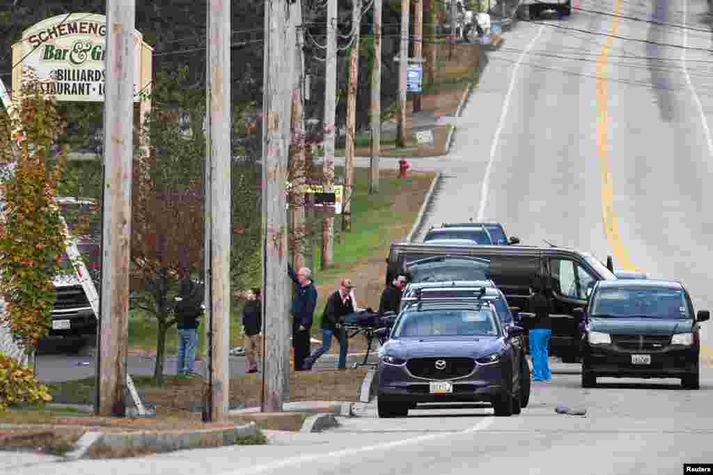 Police remove a victim from the Schemengees Bar & Grille Restaurant after deadly mass shootings in Lewiston, Maine.