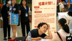 2023年6月9日北京一家購物中心招聘會上一名招聘人員與應徵者交談