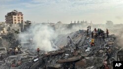 2023年10月31日，以色列空袭加沙地带努塞拉特难民营后，巴勒斯坦人寻找幸存者。（美联社照片）