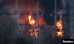 Asap dan api terlihat di sekitar saluran tegangan tinggi di lokasi serangan rudal Rusia, di tengah serangan Rusia ke Ukraina, di luar Kharkiv, Ukraina 22 Maret 2024. (REUTERS/Sofiia Gatilova)