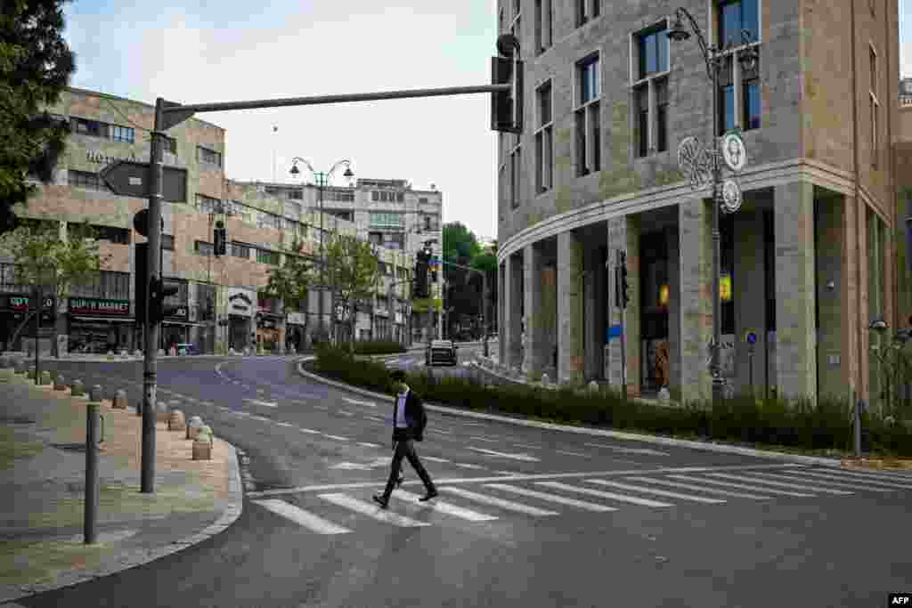 A man crosses an empty street in Jerusalem, April 14, 2024. Iran's unprecedented attack on Israel has been "foiled," the Israeli army announced, with almost all of the more than 200 missiles and drones intercepted with the help of the United States and allies. 