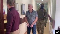 Robert Šonov u pratnji policije ulazi u sudnicu, maj 2023.