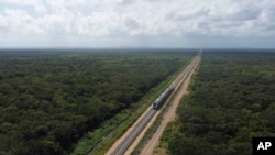 The inaugural train with President Andrés Manuel López Obrador on board passes near Chochola, Quintana Roo State, Mexico, Dec. 15, 2023.