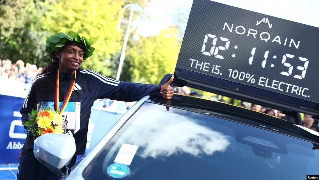 Gold medalist Ethiopia's Tigist Assefa poses next to a time board after winning the women's Berlin Marathon, Sept. 24, 2023.