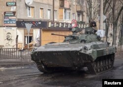 Ukrainian service members ride a BMP-2 infantry fighting vehicle on an empty street, as Russia's attack on Ukraine continues, in the frontline city of Bakhmut, Ukraine, Feb. 27, 2023.