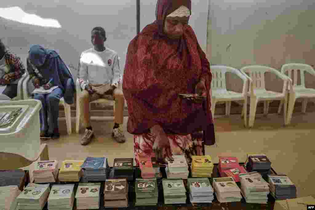 A woman picks up a ballot while voting at a polling station in Dakar, March 24, 2024 during the Senegalese presidential elections.