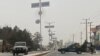 Personel keamanan Taliban (kanan) memblokir jalan di Mazar-i-Sharif , menyusul ledakan di kantor gubernur Taliban Mohammad Dawood Muzammil, di provinsi Balkh Afghanistan, 9 Maret 2023. (Atif ARYAN/AFP)