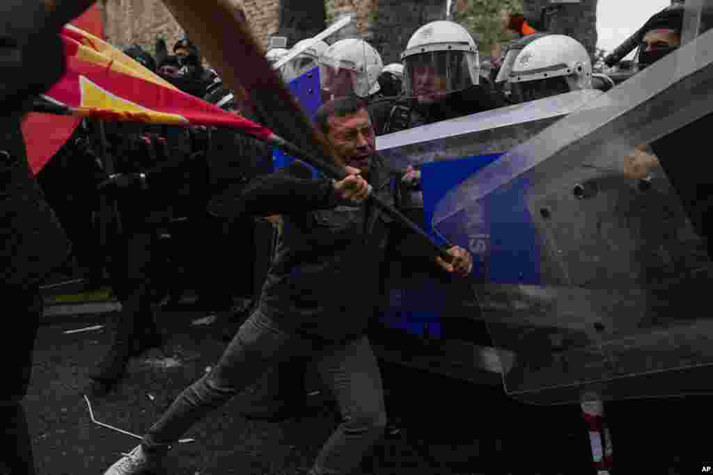 Anggota serikat pekerja bentrok dengan polisi anti huru hara Turki, saat pawai perayaan Hari Buruh di Istanbul, Turki, 1 Mei 2024. (AP Photo/Khalil Hamra)