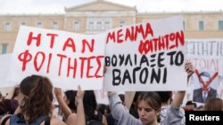Protesters hold banners during a demonstration in front of the parliament building, following the fatal collision of two trains, in Athens, March 12, 2023. The banners read 'They were students. The train car sank with students' blood.'
