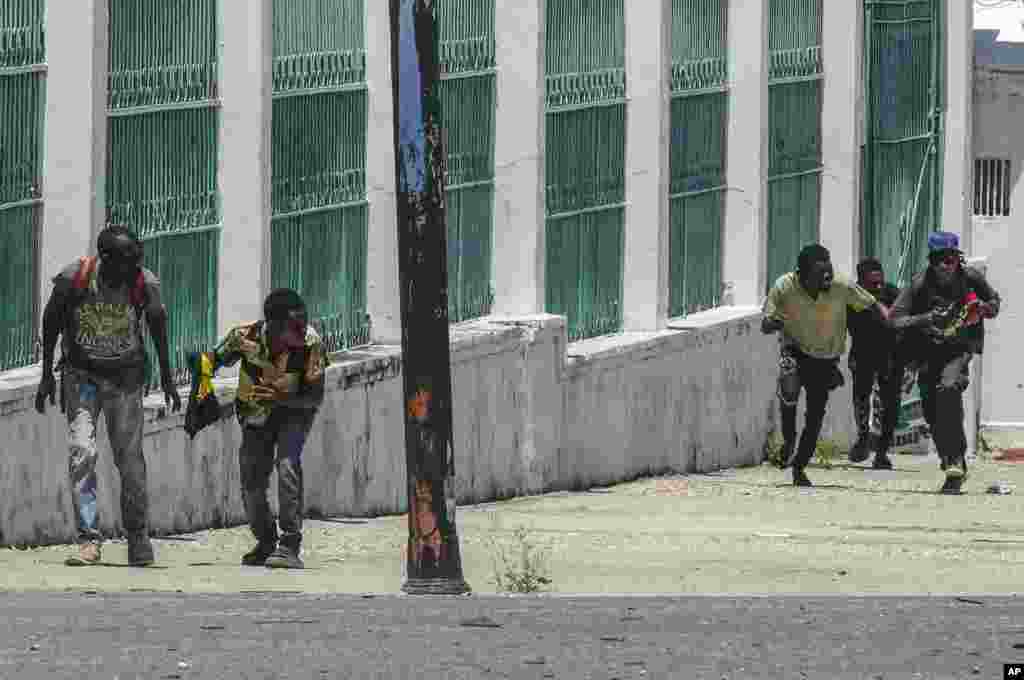 Orang-orang berlari mencari perlindungan saat tembakan terdengar di dekat Istana Nasional, di Port-au-Prince, Haiti, Selasa, 30 April 2024. (AP/Ramon Espinosa)