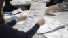 FILE - An election worker examines a ballot on May 19, 2022, in Oregon City, Oregon. No Labels, a group that could shake up the 2024 U.S. presidential race with a bipartisan "unity ticket," secured access to the ballot in Oregon on March 10, 2023.