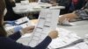FILE - An election worker examines a ballot on May 19, 2022, in Oregon City, Ore. 