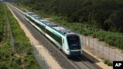 The inaugural train with President Andrés Manuel López Obrador on board passes near Chochola, Quintana Roo State, Mexico, Dec. 15, 2023. 