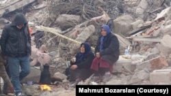 شماری از باشندگان ترکیه در نزدیکی یکی از ساختمانهای ویران شده