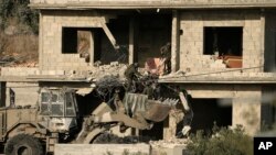 FILE - Israeli forces remove a body of a man killed during a military operation in the West Bank town of Qabatiya, June 13, 2024.