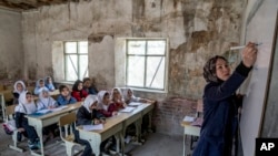 FILE - A teacher leads a class of girls on the first day of the school year, in Kabul, Afghanistan, March 25, 2023.