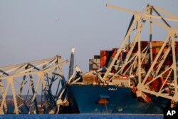 Cranes stand by the wreckage of the Francis Scott Key Bridge in Baltimore, Maryland, March 30, 2024.