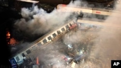 FILE - Smoke rises from a train as firefighters and rescuers operate after a collision near Larissa city, Greece, early March 1, 2023.