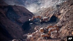 In this photo released by China's Xinhua News Agency, rescuers work at the site of a collapsed open pit coal mine in Alxa League in northern China's Inner Mongolia Autonomous Region, Feb. 23, 2023. 